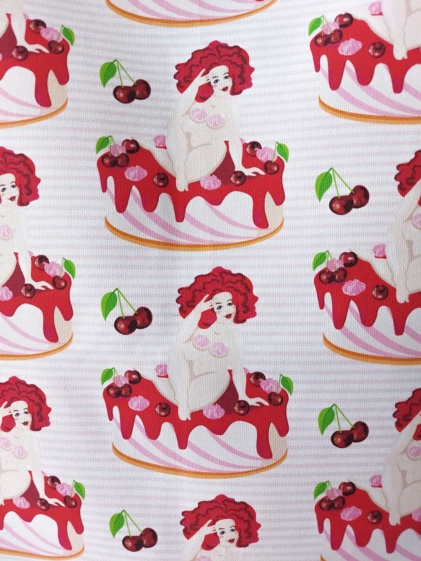 Close up of the Cake Nudes tea towel showing nude woman sitting on top of a cake with cherries