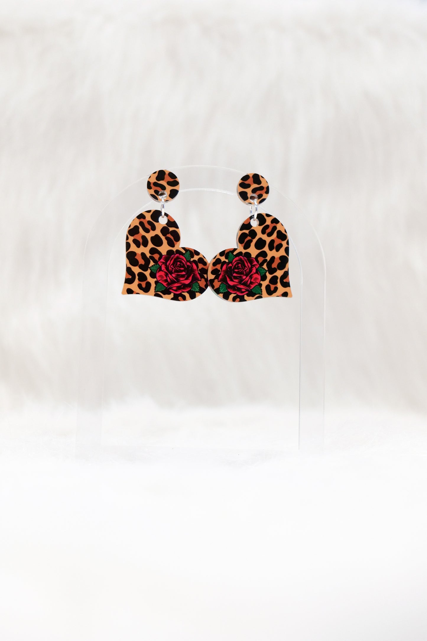 Leopard print earrings with red floral centers on a white background