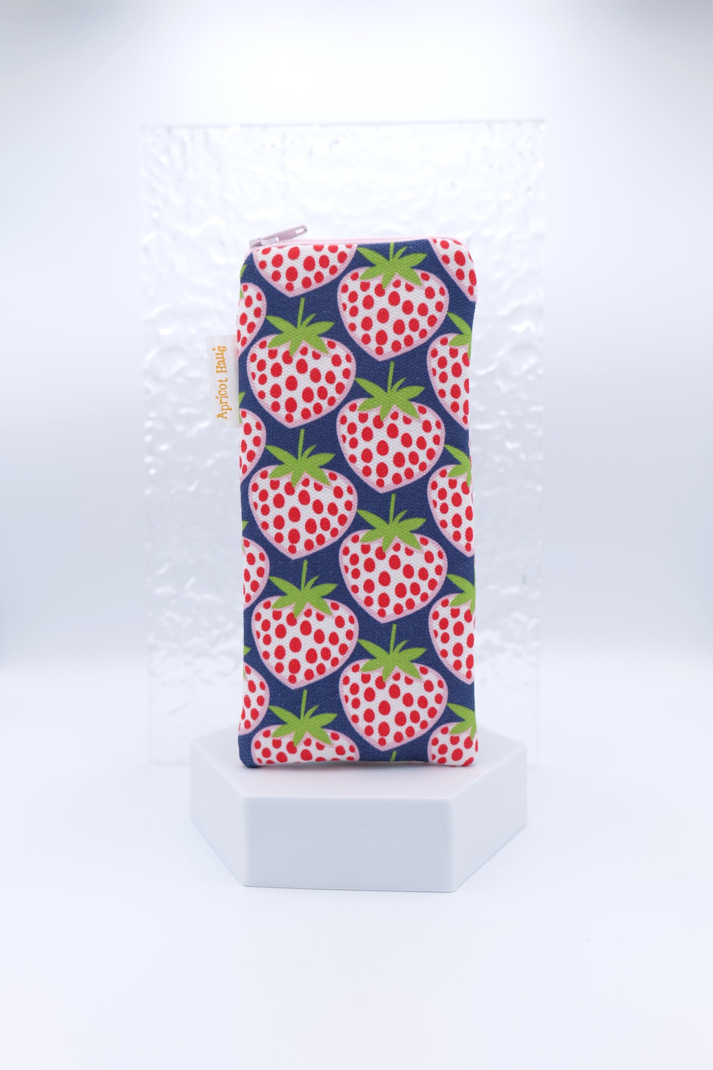 Glasses case featuring a Blue Strawberries design with oversized red and white strawberries scattered across a navy background; made from cotton canvas with a zip‑top closure, padded and lined to protect lenses, handmade in Melbourne and certified Australian Made; pattern placement may vary slightly due to the handmade nature of the product.