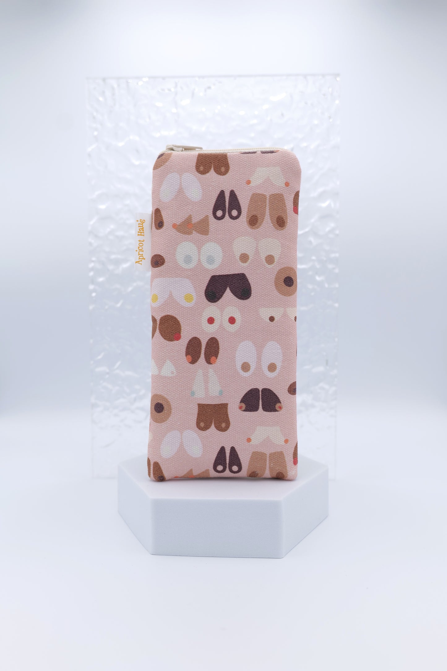 Glasses case with Breasts design featuring abstract, stylised illustrations of breasts in varied shapes and tones on a soft pink background; made from cotton canvas with zip top closure, padded and lined with soft cotton, handmade in Melbourne and certified Australian Made; matching apron and tea towel available; pattern placement may vary slightly and individual items may have small quirks due to the handmade nature of the product.