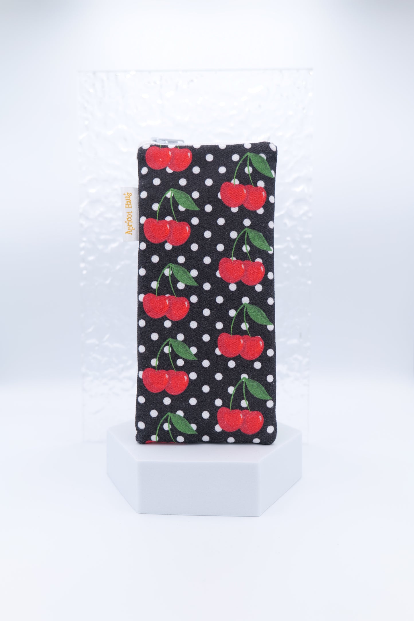 Glasses case featuring the Cherries on Black design with red cherries, green leaves and white polka dots on a black background; made from cotton canvas with a zip-top closure, padded and lined to protect lenses, handmade in Melbourne and certified Australian Made; pattern placement may vary slightly due to the handmade nature of the product.