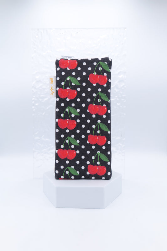 Glasses case featuring the Cherries on Black design with red cherries, green leaves and white polka dots on a black background; made from cotton canvas with a zip-top closure, padded and lined to protect lenses, handmade in Melbourne and certified Australian Made; pattern placement may vary slightly due to the handmade nature of the product.
