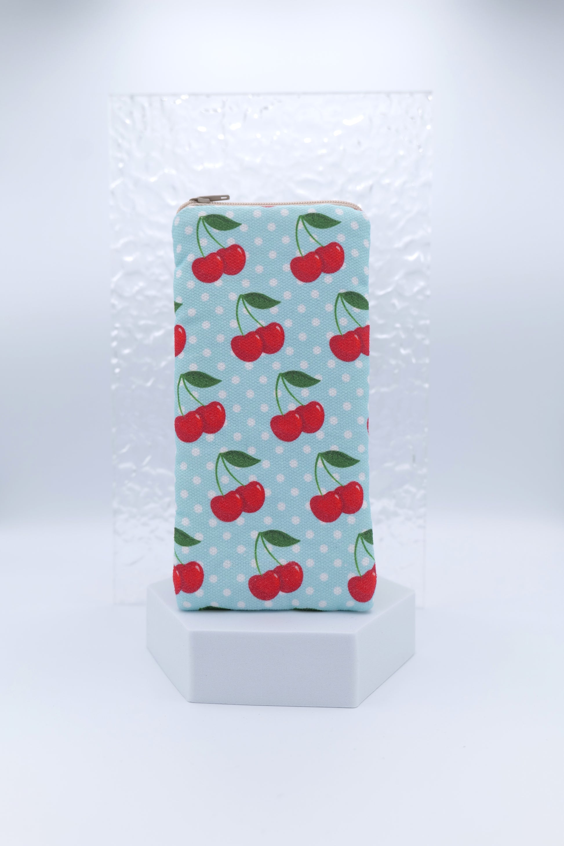 Glasses case with Cherries on Blue design featuring bright red cherries with green stems on a soft blue background with white polka dots; made from cotton canvas with zip top closure, padded and lined with soft cotton, handmade in Melbourne and certified Australian Made; pattern placement may vary slightly and individual items may have small quirks due to the handmade nature of the product.
