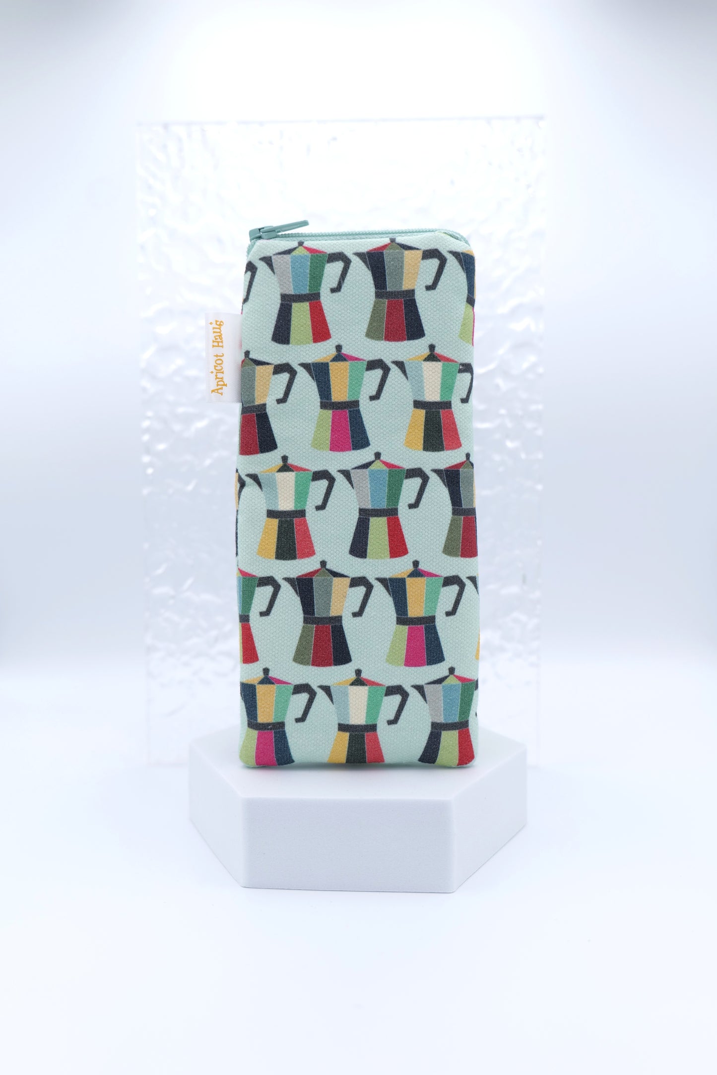 Glasses case featuring a Coffee Pot design with colourful moka pots in red, green, yellow, pink and black on a pale blue background; made from cotton canvas with a zip-top closure, padded and lined to protect lenses, handmade in Melbourne and certified Australian Made; matching tea towel available; pattern placement may vary slightly due to the handmade nature of the product.