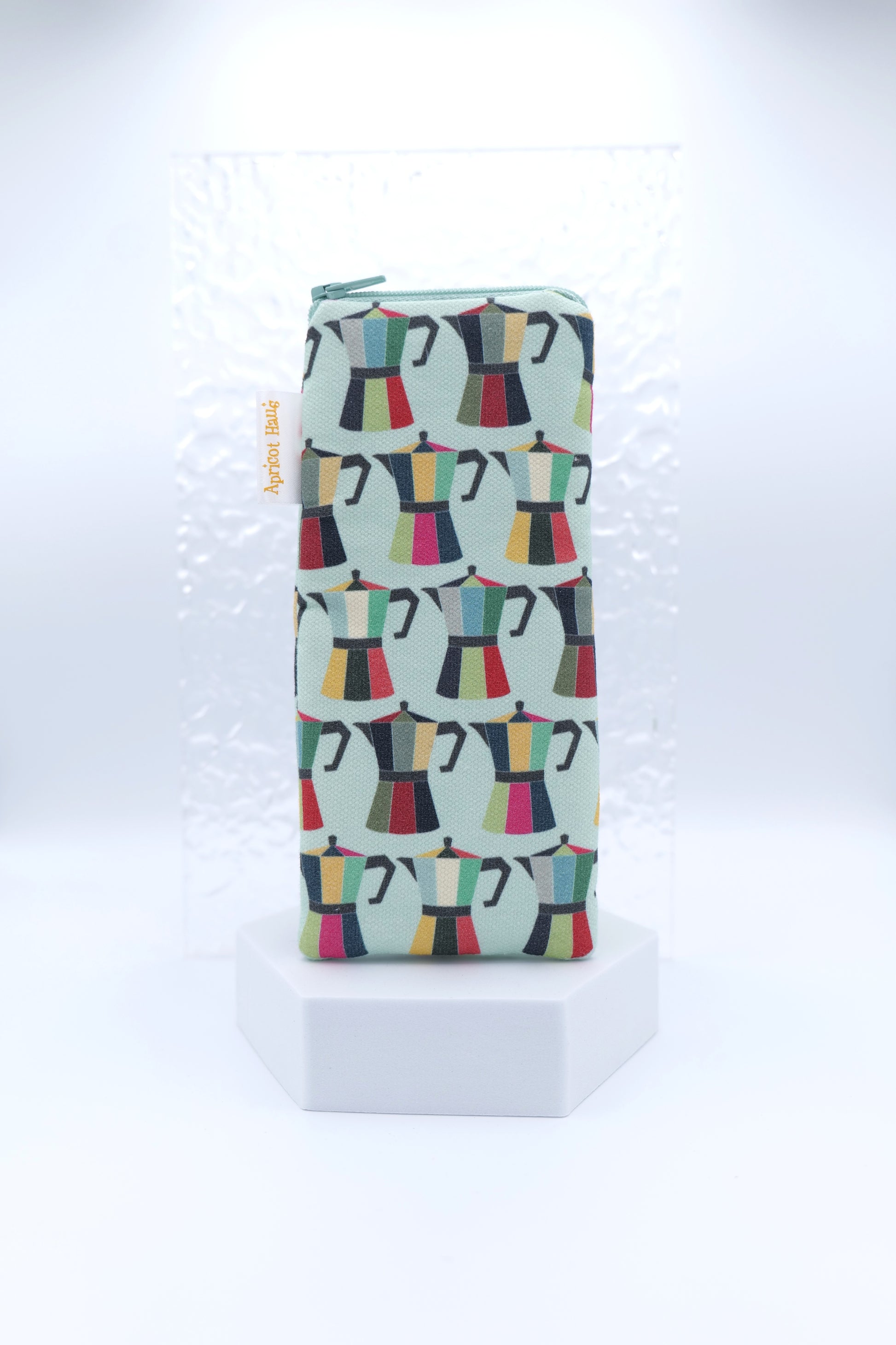 Glasses case featuring a Coffee Pot design with colourful moka pots in red, green, yellow, pink and black on a pale blue background; made from cotton canvas with a zip-top closure, padded and lined to protect lenses, handmade in Melbourne and certified Australian Made; matching tea towel available; pattern placement may vary slightly due to the handmade nature of the product.