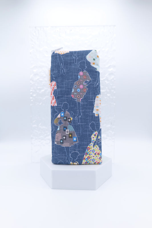 Glasses case featuring the Dressmakers design with outlined women in 1950s-style dresses, each filled with a unique patterned print, set against a navy background; made from cotton canvas with a zip-top closure, padded and lined to protect lenses, handmade in Melbourne and certified Australian Made; pattern placement may vary slightly due to the handmade nature of the product.