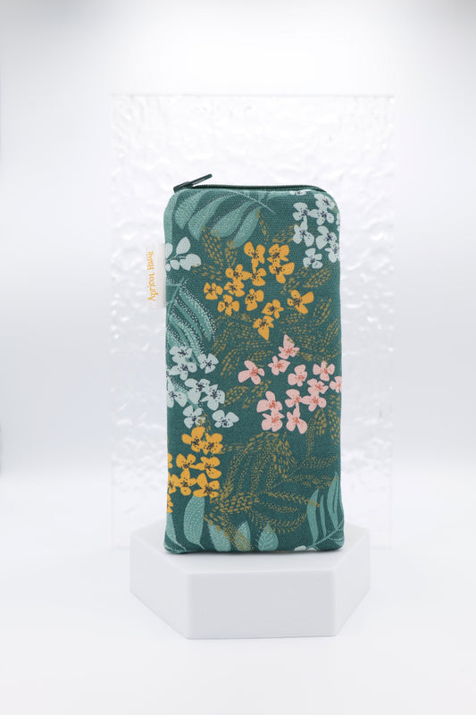 Glasses case featuring an Emerald Leaves design with lush green foliage and soft florals on a dark green background; made from cotton canvas with a zip-top closure, padded and lined to protect lenses, handmade in Melbourne and certified Australian Made; pattern placement may vary slightly due to the handmade nature of the product.