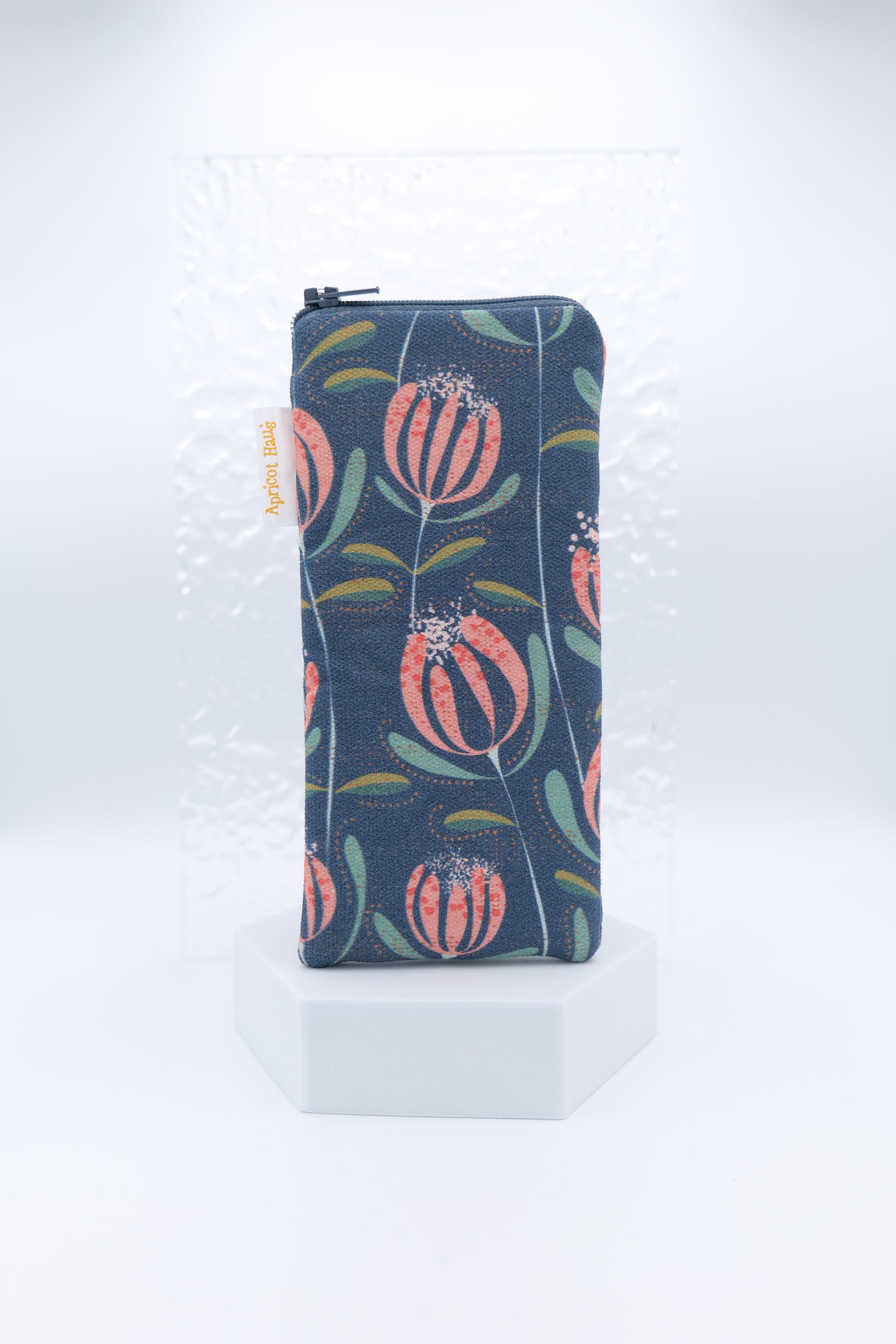 Glasses case with Floating Skandi Flowers design featuring stylised pink and coral flowers with green leaves on a navy background; made from cotton canvas with zip top closure, padded and lined with soft cotton, handmade in Melbourne and certified Australian Made; pattern placement may vary slightly and individual items may have small quirks due to the handmade nature of the product.