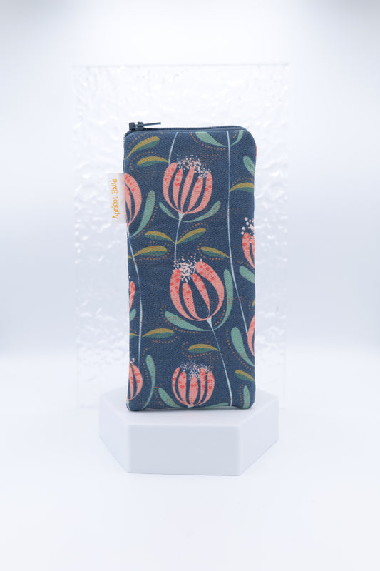 Glasses case with Floating Skandi Flowers design featuring stylised pink and coral flowers with green leaves on a navy background; made from cotton canvas with zip top closure, padded and lined with soft cotton, handmade in Melbourne and certified Australian Made; pattern placement may vary slightly and individual items may have small quirks due to the handmade nature of the product.