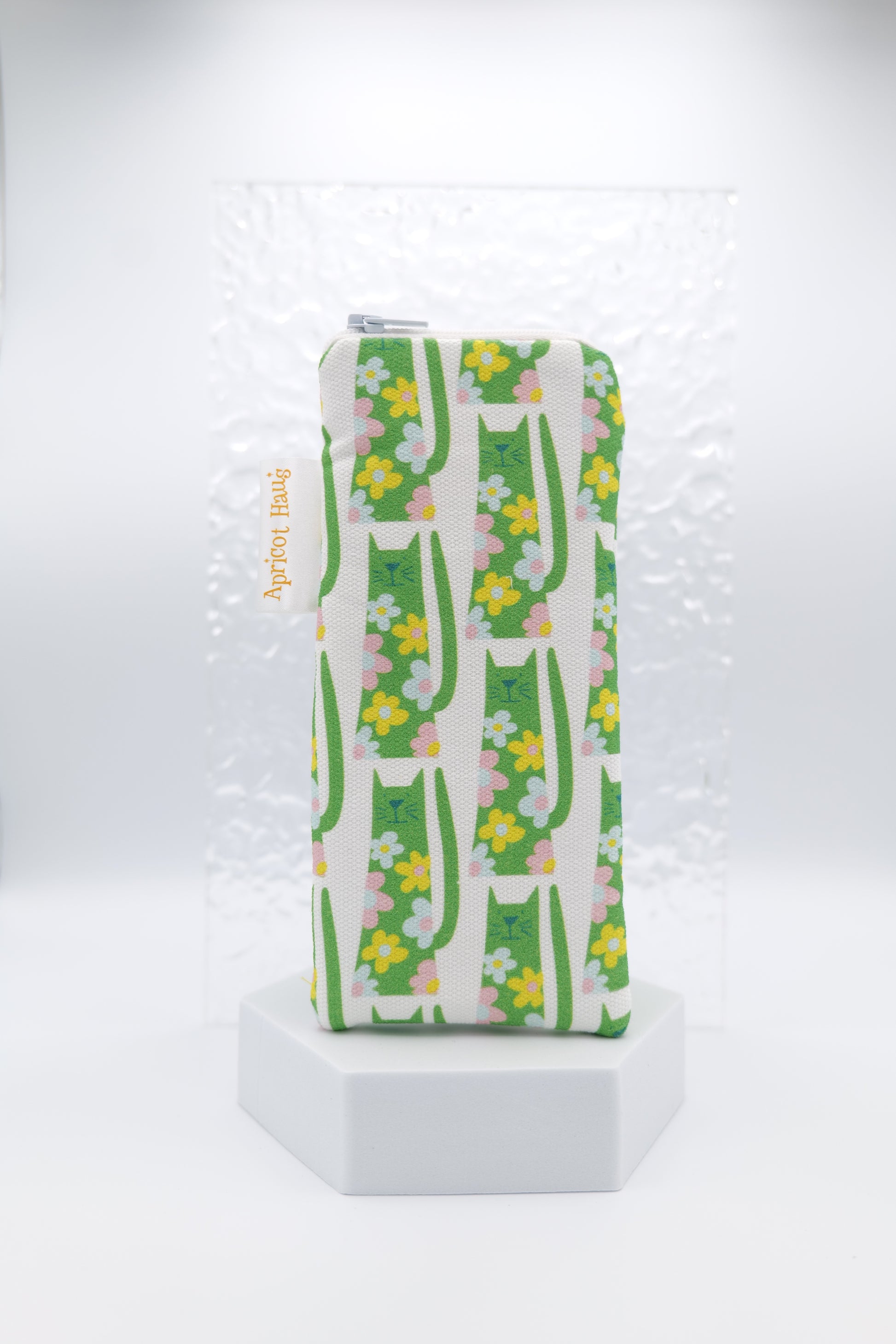 Glasses case with Flower Power Cats design featuring upright green cats decorated with pink and yellow floral motifs on a white background; made from cotton canvas with zip top closure, padded and lined with soft cotton, handmade in Melbourne and certified Australian Made; pattern placement may vary slightly due to the handmade nature of the item.