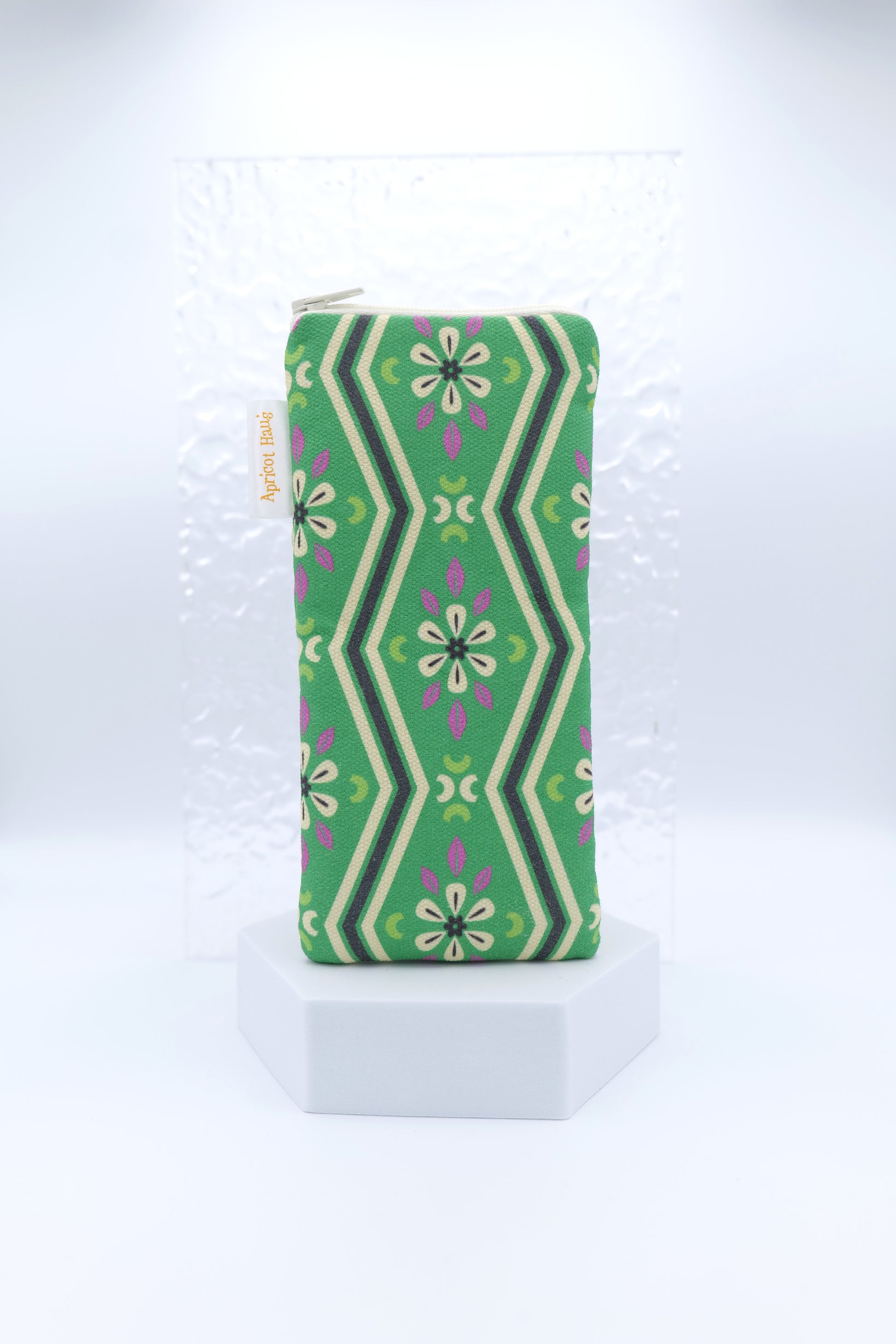 Glasses case with Green Pavilion design featuring symmetrical floral and geometric motifs in green, cream, black and purple; made from cotton canvas with zip top closure, padded and lined with soft cotton, handmade in Melbourne and certified Australian Made.