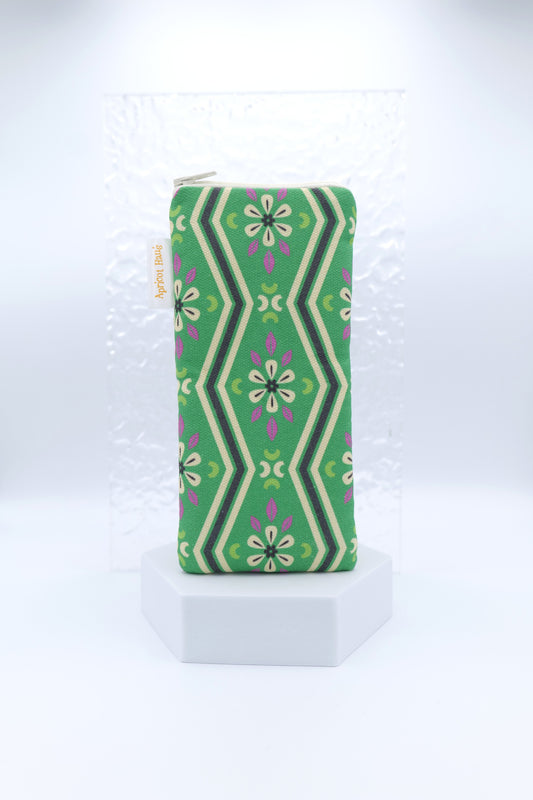 Glasses case with Green Pavilion design featuring symmetrical floral and geometric motifs in green, cream, black and purple; made from cotton canvas with zip top closure, padded and lined with soft cotton, handmade in Melbourne and certified Australian Made.