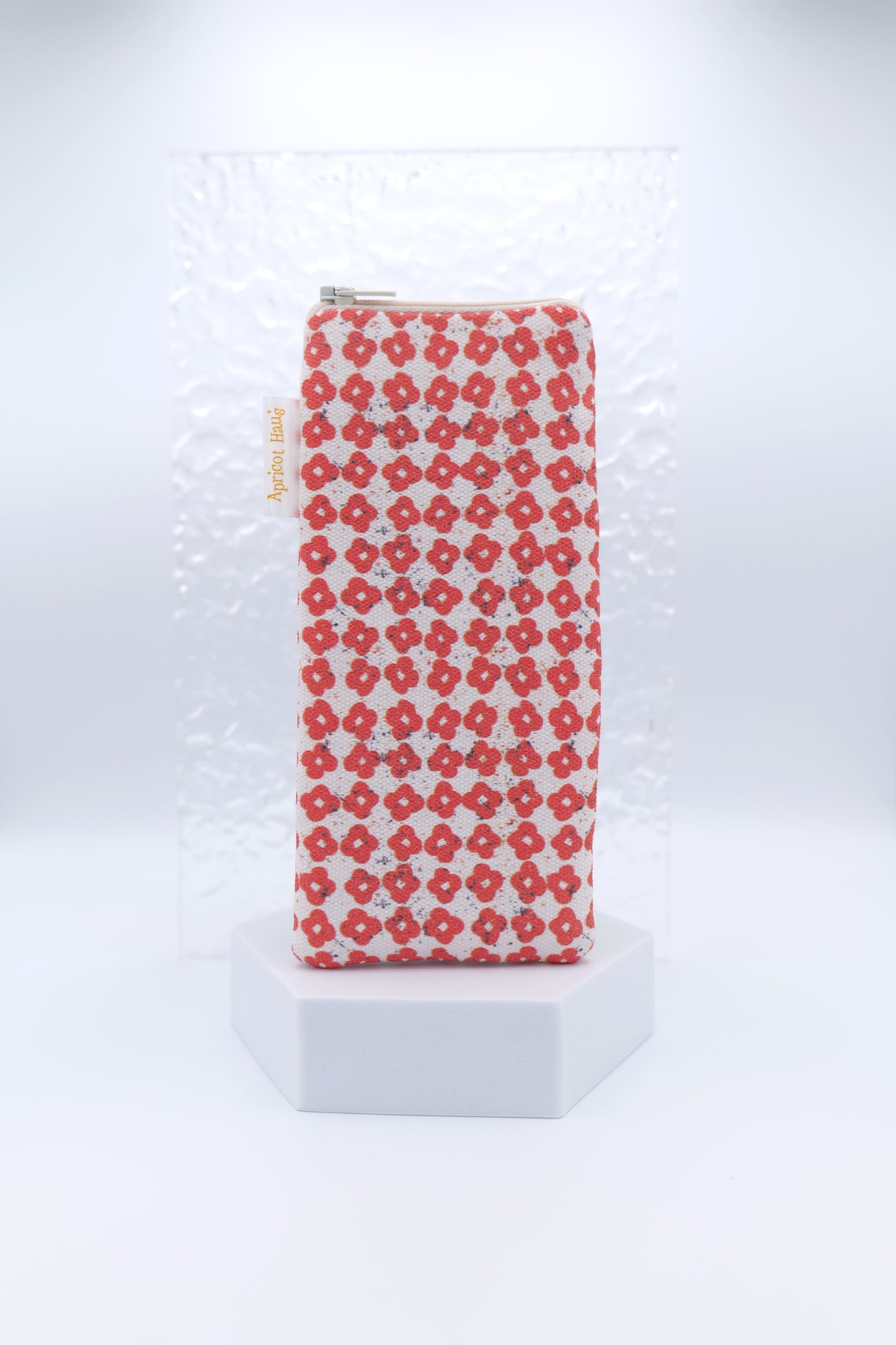 Glasses case featuring the Nordic Flowers Red design with a repeating grid of small red four‑petal flowers on a soft cream background; made from cotton canvas with a zip‑top closure, padded and lined to protect lenses, handmade in Melbourne and certified Australian Made; pattern placement may vary slightly due to the handmade nature of the product.