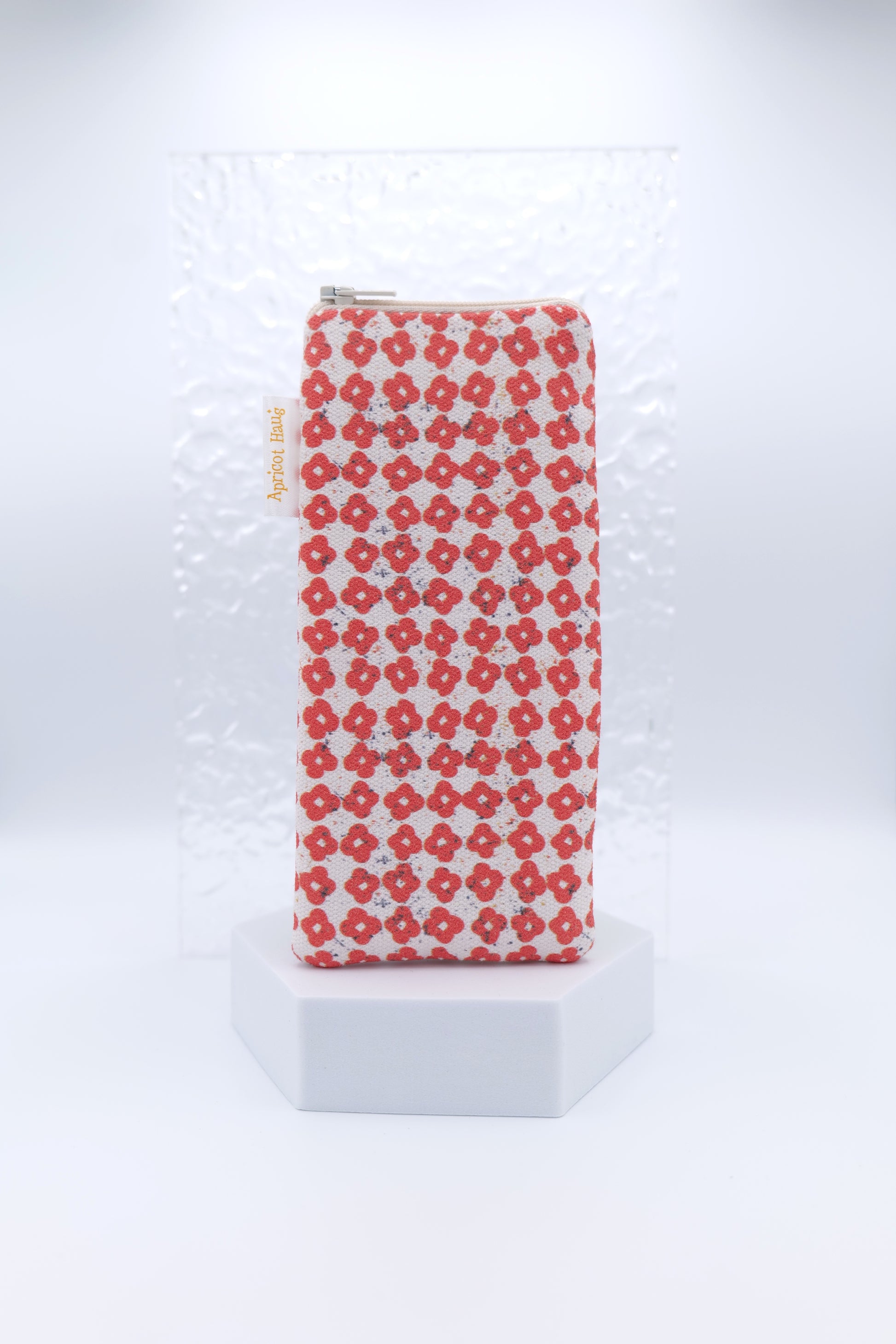 Glasses case featuring the Nordic Flowers Red design with a repeating grid of small red four‑petal flowers on a soft cream background; made from cotton canvas with a zip‑top closure, padded and lined to protect lenses, handmade in Melbourne and certified Australian Made; pattern placement may vary slightly due to the handmade nature of the product.