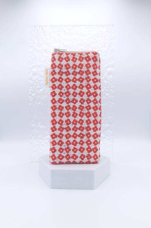 Glasses case featuring the Nordic Flowers Red design with a repeating grid of small red four‑petal flowers on a soft cream background; made from cotton canvas with a zip‑top closure, padded and lined to protect lenses, handmade in Melbourne and certified Australian Made; pattern placement may vary slightly due to the handmade nature of the product.