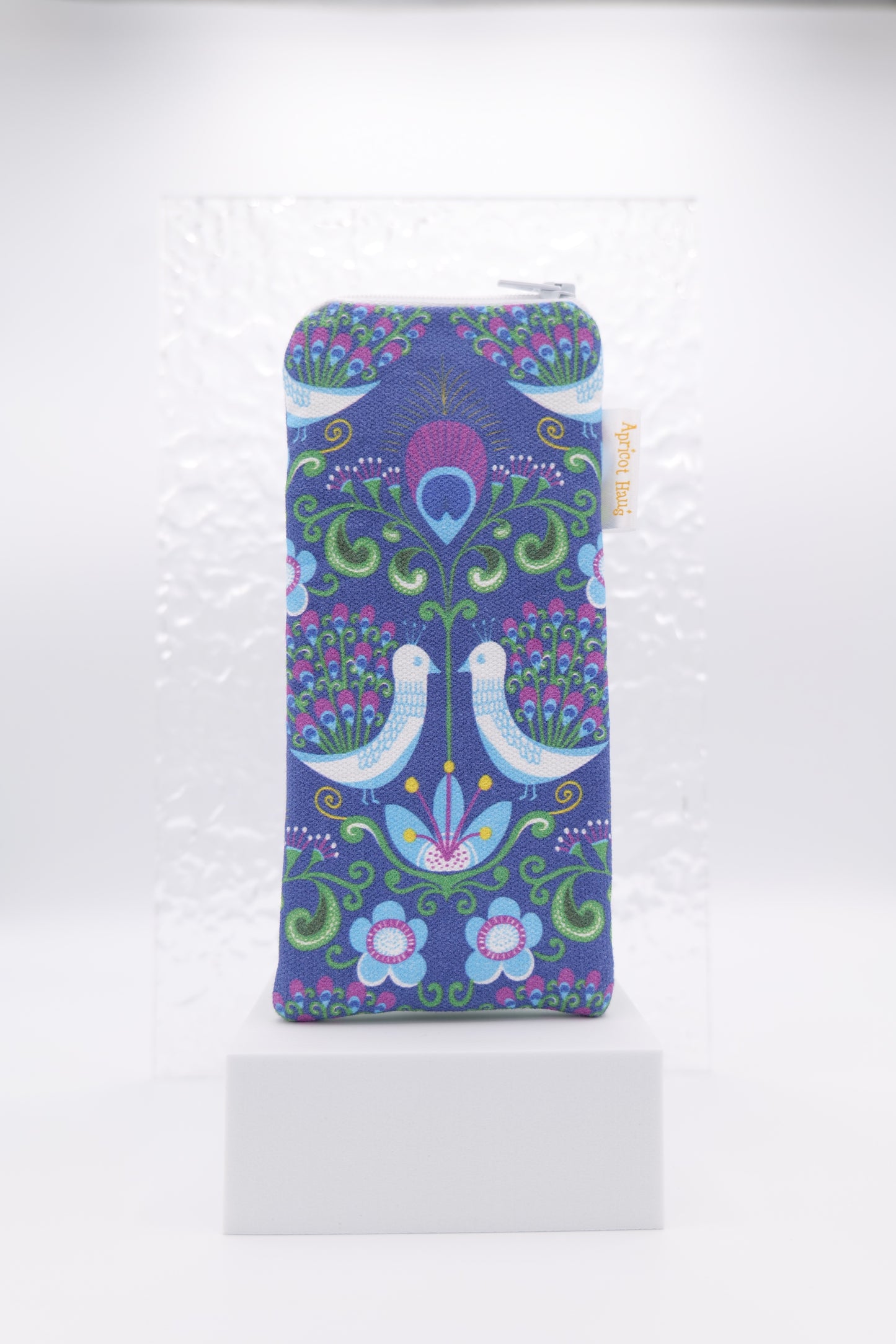 Glasses case with retro Peacock design featuring two white birds with peacock feathers surrounded by floral motifs in vibrant shades of blue, green and purple; made from cotton canvas with zip top closure, padded and lined with soft cotton, handmade in Melbourne and certified Australian Made; pattern placement may vary slightly due to the handmade nature of the item.