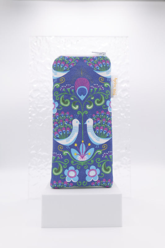 Glasses case with retro Peacock design featuring two white birds with peacock feathers surrounded by floral motifs in vibrant shades of blue, green and purple; made from cotton canvas with zip top closure, padded and lined with soft cotton, handmade in Melbourne and certified Australian Made; pattern placement may vary slightly due to the handmade nature of the item.