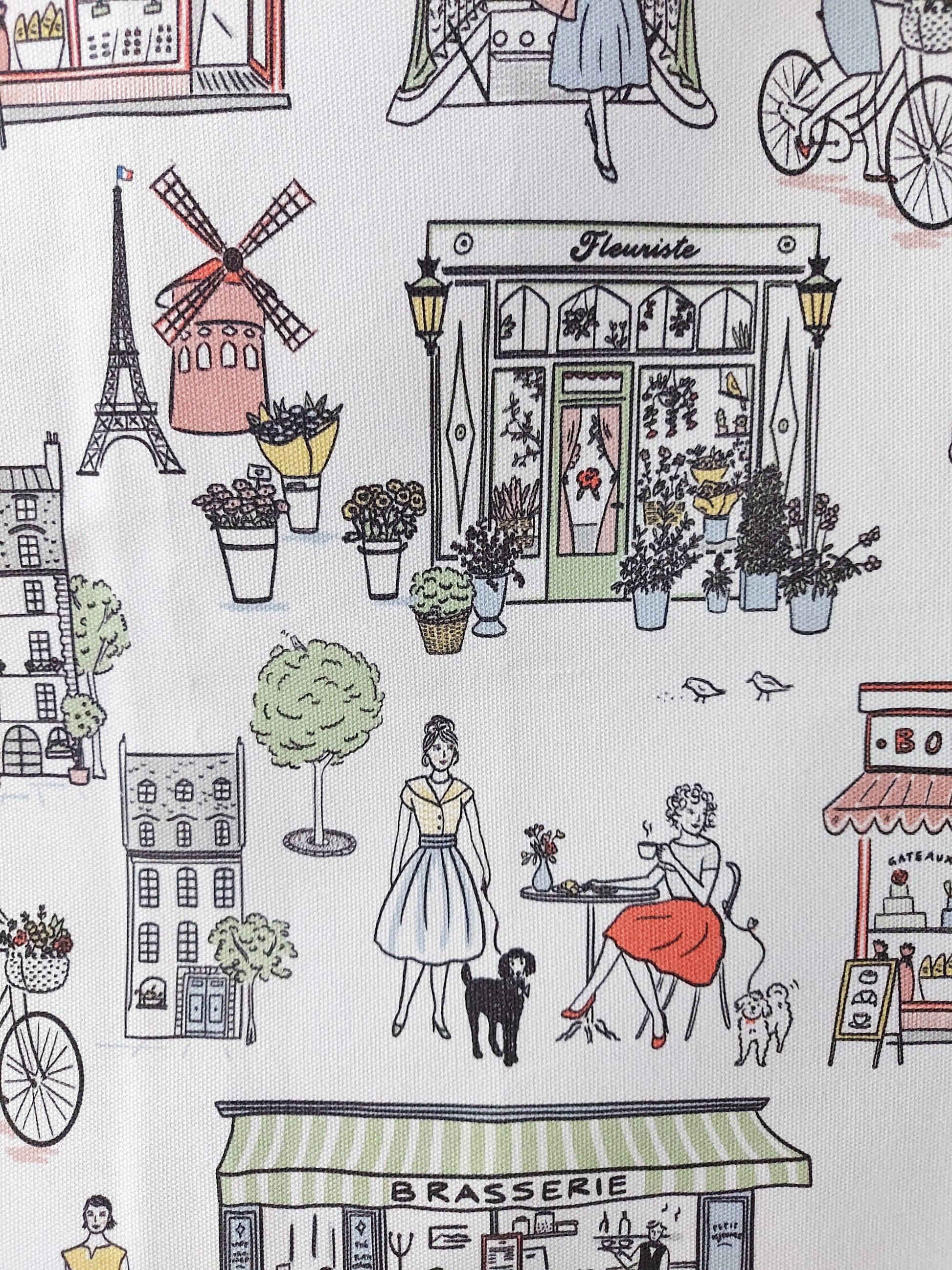 A close up of the Retro Paris design featuring two girls at a cafe and French buildings on a white background