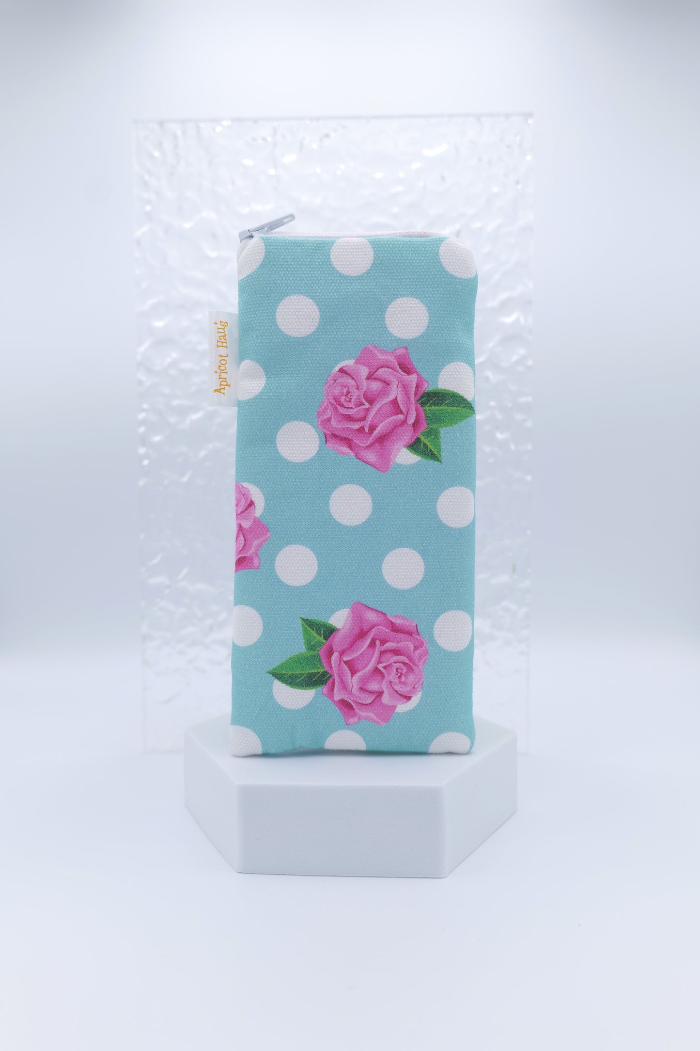 Glasses case featuring the Rosie on Blue design with pink roses and green leaves on a pale blue background with white spots; made from cotton canvas with a zip‑top closure, padded and lined to protect lenses, handmade in Melbourne and certified Australian Made; pattern placement may vary slightly due to the handmade nature of the product.