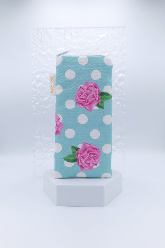Glasses case featuring the Rosie on Blue design with pink roses and green leaves on a pale blue background with white spots; made from cotton canvas with a zip‑top closure, padded and lined to protect lenses, handmade in Melbourne and certified Australian Made; pattern placement may vary slightly due to the handmade nature of the product.
