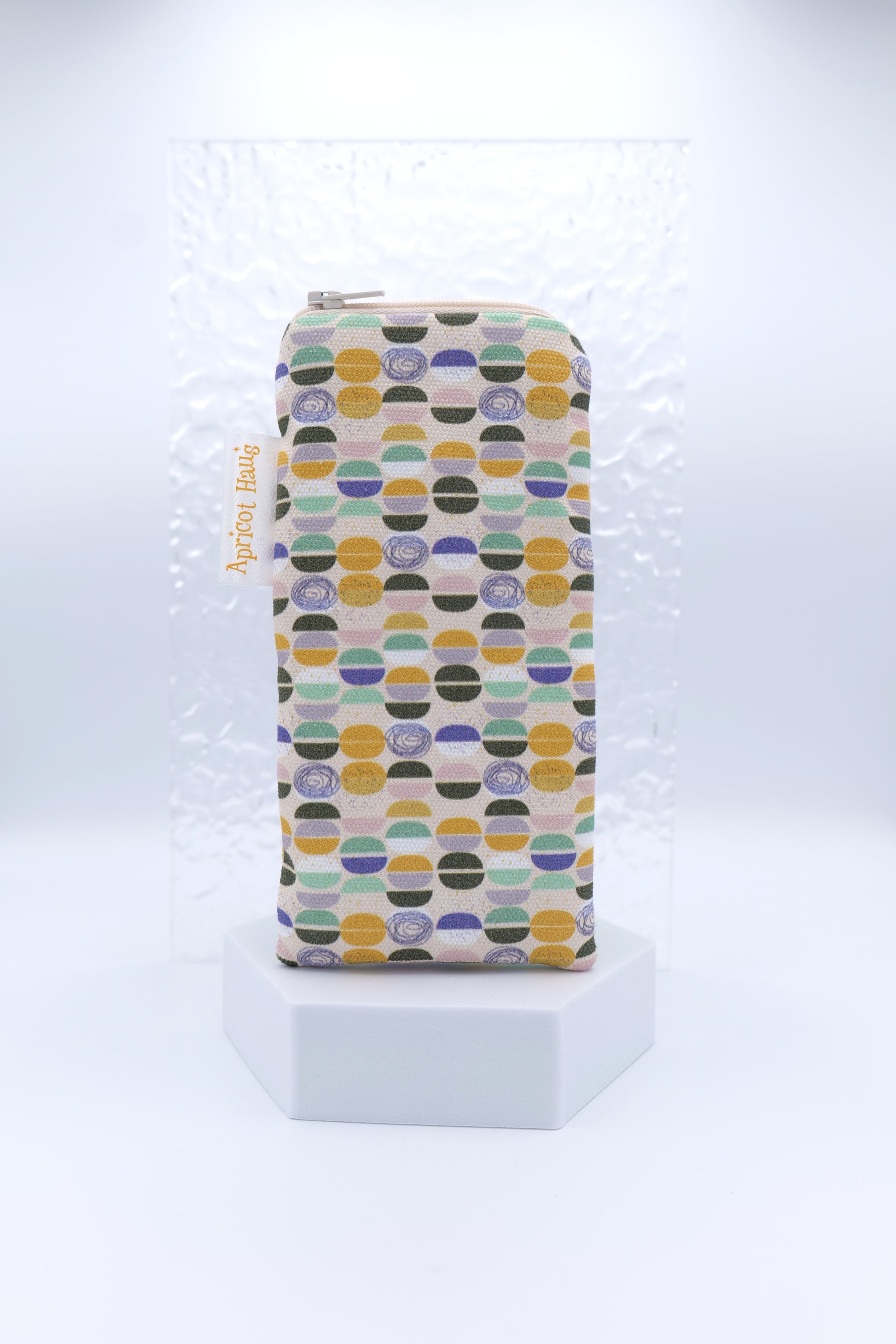 Glasses case featuring a Semicircles design with colourful circular and semicircular motifs in yellow, black, green, purple and blue on a soft background; made from cotton canvas with a zip-top closure, padded and lined to protect lenses, handmade in Melbourne and certified Australian Made; pattern placement may vary slightly due to the handmade nature of the product.