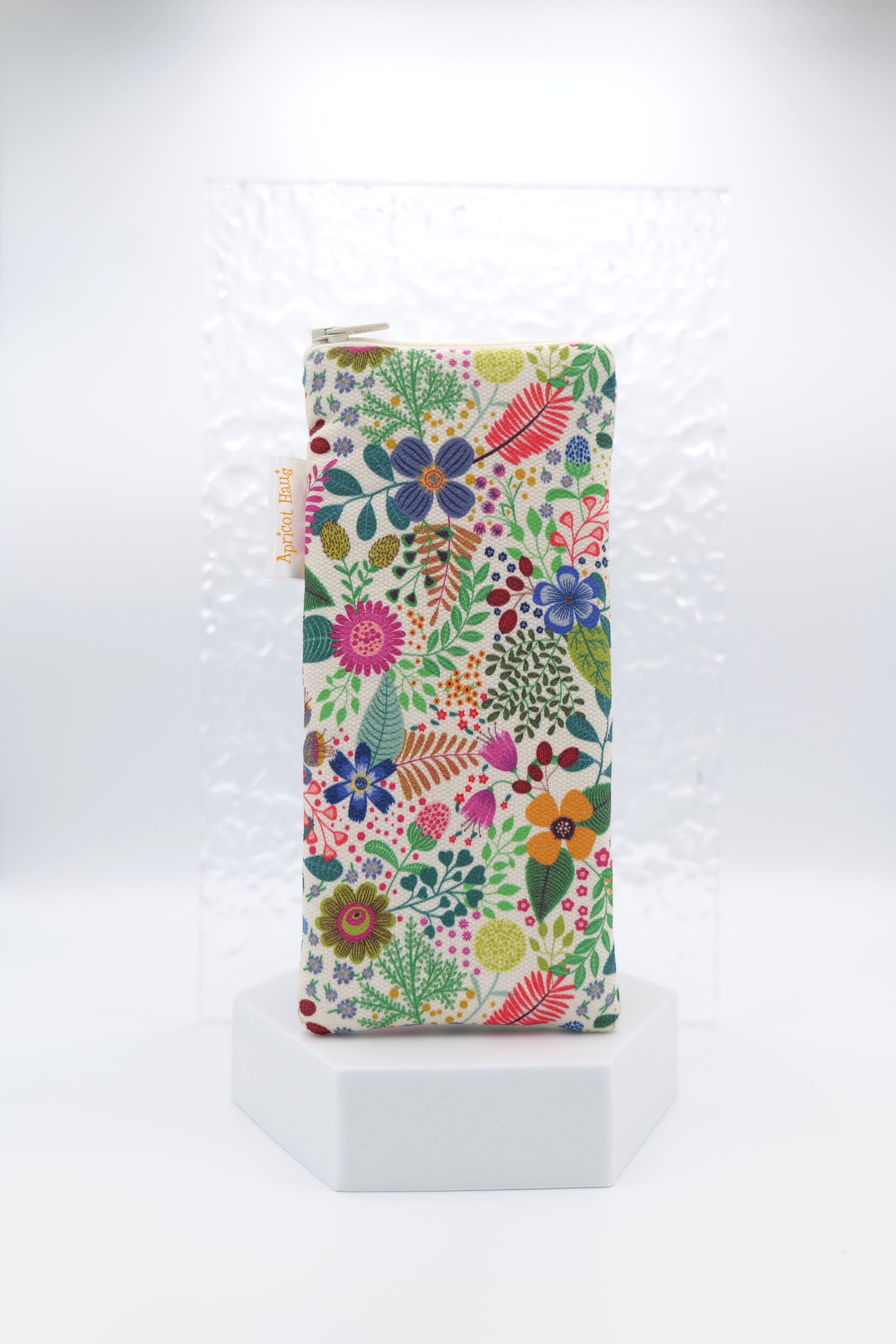 Glasses case featuring the Spring Garden design inspired by folk art, with colourful florals and leaves in pink, blue, red, yellow, green and orange on a soft mint background; made from cotton canvas with a zip‑top closure, padded and lined to protect lenses, handmade in Melbourne and certified Australian Made; matching apron and tea towel available.