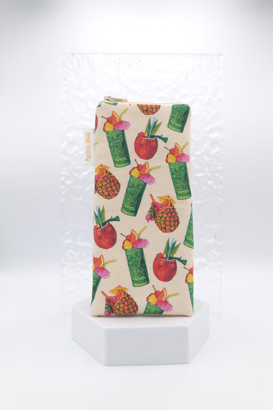 Glasses case featuring the Tiki Cocktail design with colourful illustrations of tiki mugs, pineapples, coconuts and tropical drinks on a cream background; made from cotton canvas with a zip-top closure, padded and lined to protect lenses, handmade in Melbourne and certified Australian Made; pattern placement may vary slightly due to the handmade nature of the product.